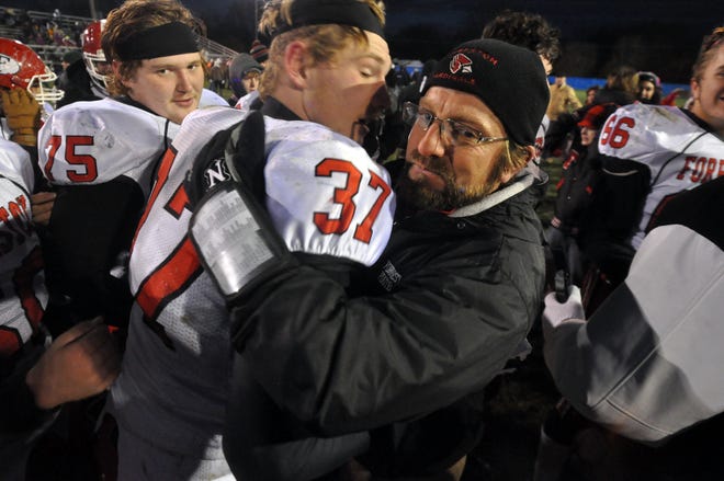 Forreston head coach Denny Diduch hugs junior Gavin Fuchs (37) after the Cardinals' 2016 Class 1A state semifinal win at Ottawa Marquette. Diduch has been hired to become an assistant coach at Guilford. [RRSTAR.COM & THE JOURNAL-STANDARD FILE PHOTO]