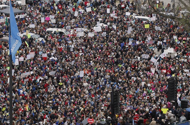 In an April 2, file photo, a crowd listens to speakers on a stage during a teacher rally to protest low student funding at the state Capitol in Oklahoma City. Tens of thousands of North Carolina teachers are heading to North Carolina's Capitol Wednesday to call for better pay.. (AP Photo/Sue Ogrocki)