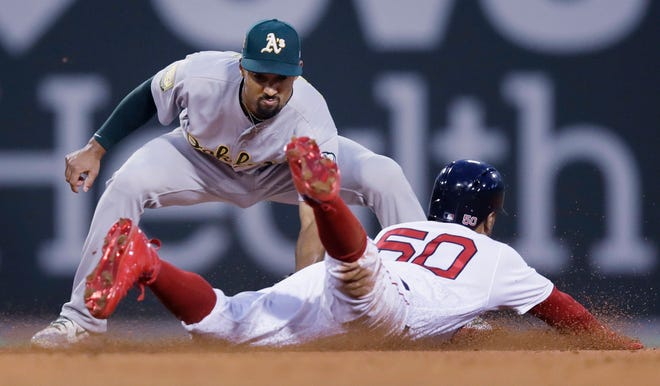 Oakland's Marcus Semien tags out Boston's Mookie Betts on a steal attempt in the second inning on Wednesday night.