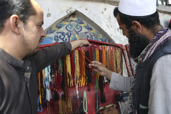 A customer purchases prayer beads ahead of the upcoming holy fasting month of Ramadan in Kabul, Afghanistan, Wednesday. Muslims across the world are observing the holy fasting month of Ramadan, when they refrain from eating, drinking and smoking from dawn to dusk. [AP Photo/Rahmat Gul]