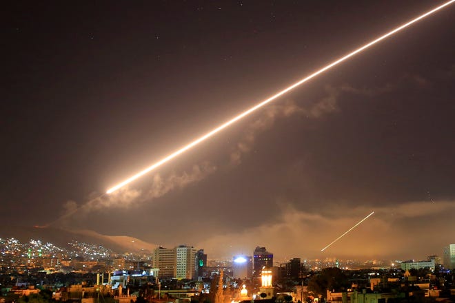 FILE - In this April 14, 2018 file photo, Damascus skies erupt with surface to air missile fire as the U.S. launches an attack on Syria targeting different parts of the Syrian capital Damascus, Syria. The modern Middle East has been plagued by ruinous wars: country versus country, civil wars with internecine and sectarian bloodletting, and numerous eruptions centered in the Israeli-Palestinian conflict. But never in the last 70 years have they seemed as interconnected as now with Iran and Saudi Arabia vying for regional control, while Israel also seeks to maintain a military supremacy of its own.(AP Photo/Hassan Ammar, File)