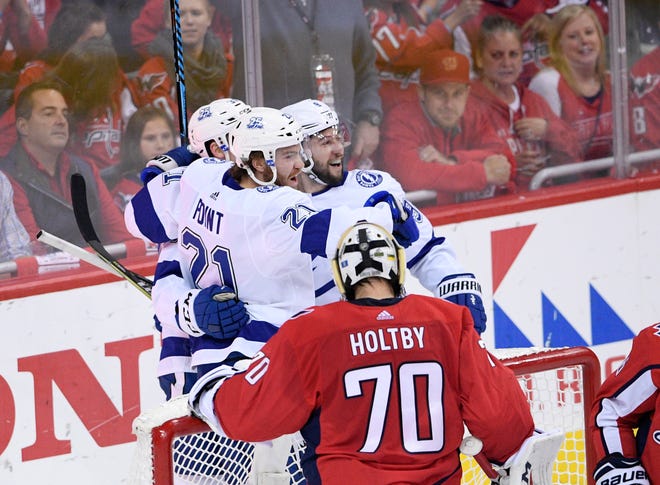 Tampa Bay Lightning center Brayden Point (21) celebrates his goal with center Tyler Johnson (9) next to Washington Capitals goaltender Braden Holtby (70) during the first period of Game 4 of the NHL hockey Eastern Conference finals Thursday, May 17, 2018, in Washington. (AP Photo/Nick Wass)