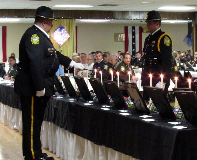 Officers light candles to honor those who have fallen in the line of duty during the Last Roll Call ceremony of the 24th Annual Tri-Cities Law Enforcement Memorial Breakfast, held at Hopewell Moose Lodge on May 17, 2018. [Kate Gibson/progress-index.com]
