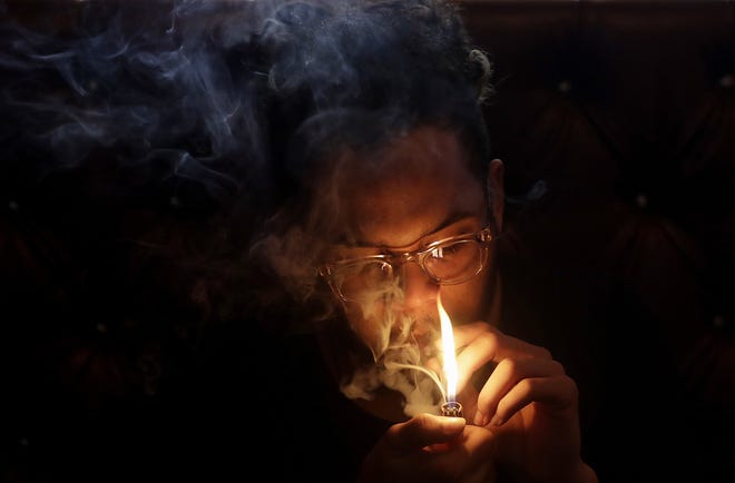 A man smokes marijuana in a smoking lounge at Barbary Coast Dispensary in San Francisco. [JEFF CHIU/AP FILE]