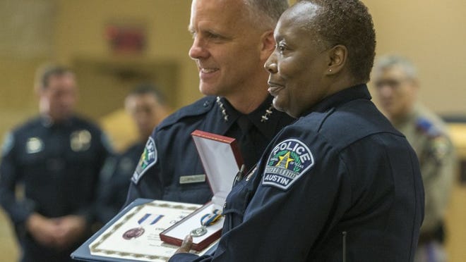 Interim Police Chief Brian Manley awards officer LaSandra Williams the Meritorious Unit Citation with Valor for actions dealing with the March bombings during a ceremony at Austin City Hall on Thursday. (Stephen Spillman / for American-Statesman)