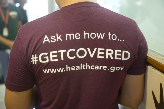 A volunteer health care worker wears a T-shirt, getting people to sign up for health care programs. Premiums for health insurance plans sold on the federal marketplace are expected to increase by nearly 16.9 percent in Florida next year due to changes in the Affordable Care Act, according to a new analysis released Friday. [AP Photo / J Pat Carter]