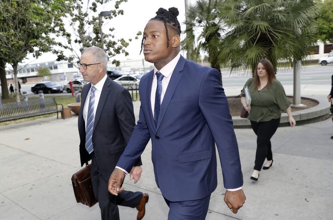 San Francisco 49ers linebacker Reuben Foster, center, arrives with his attorney Joshua Bentley, left, at Santa Clara County Superior Court, Thursday, May 17, 2018, in San Jose, Calif. Foster pleaded not guilty Tuesday, May 8, 2018, to charges stemming from allegations that he attacked his then-girlfriend in their home in February. A preliminary hearing has been scheduled today, at which point Foster's former girlfriend, Elissa Ennis, may testify under oath. (AP Photo/Marcio Jose Sanchez)