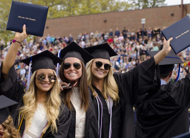 Graduating seniors show off their diplomas during the 2018 UNH commencement ceremony in Durham on Saturday. [Daryl Carlson/Fosters.com]