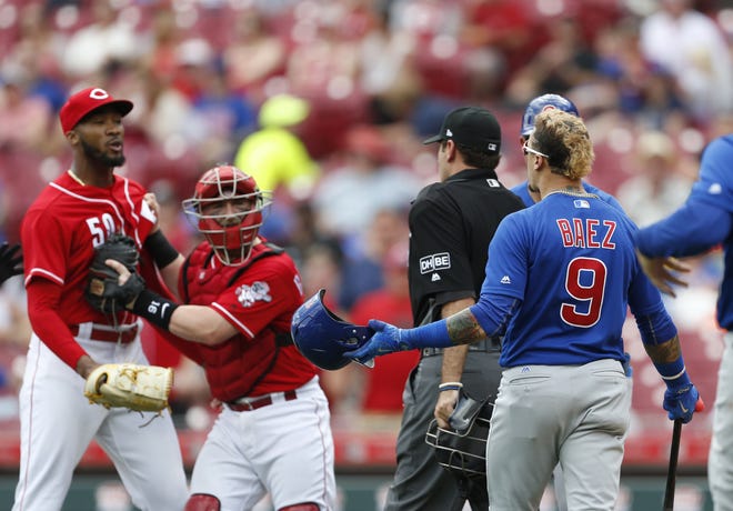 Chicago Cubs' Javier Baez (9) has a few words for Cincinnati Reds relief pitcher Amir Garrett, far left, after striking out during the seventh inning in the first baseball game of a doubleheader, Saturday, May 19, 2018, in Cincinnati. (AP Photo/Gary Landers)