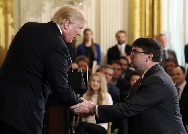 President Donald Trump shakes hands with interim Veterans Affairs Secretary Robert Wilkie during an event on prison reform in the East Room of the White House on Friday in Washington. Trump announced he's nominating Wilkie to lead the agency. [Evan Vucci/The Associated Press]