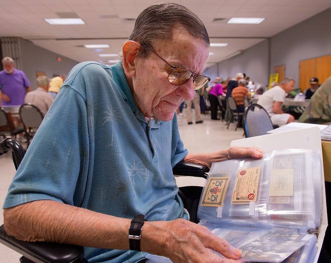 Collector William Hanes peruses German emergency money issued between the two World Wars at the Eagle Coin Club Coin Show held at the J. Smith Young YMCA on Saturday. Established in 1961, the Eagle Coin Club is the oldest continuous coin club in North Carolina. [Donnie Roberts/The Dispatch]