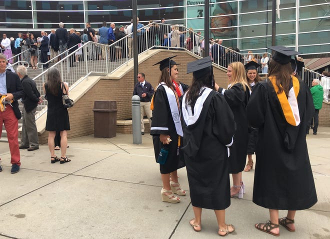 The growing crowd waits under cloudy skies for the doors to open at The Dunkin' Donuts Center for Providence College graduation Sunday morning. [The Providence Journal]