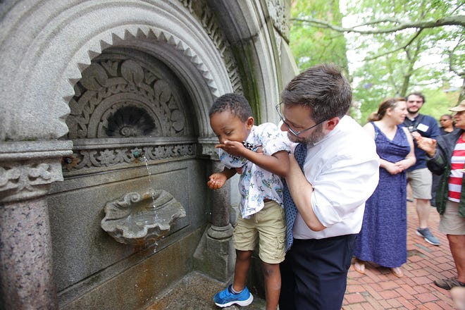 Matt Burriesci, executive director of the Providence Athenaeum, lifts his son Henry, 4, to get a drink from the fountain. [The Providence Journal / Glenn Osmundson]