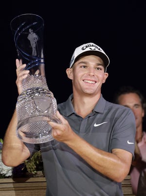 Aaron Wise holds up the trophy after winning the AT&T Byron Nelson tournament in Dallas on Sunday. [ERIC GAY/THE ASSOCIATED PRESS]