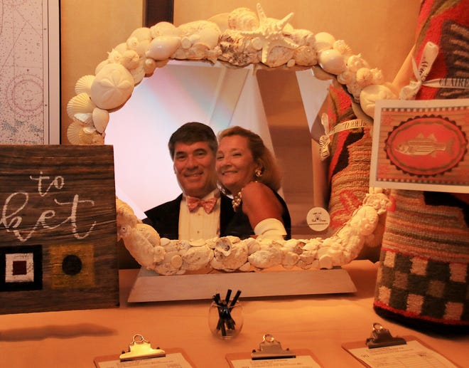 The reflections of Tom and Annalise of East Sandwich can be seen on a silent auction item: a custom, hand-made mirror from Cape Cod Shell Design. (BP photo/William F. Pomeroy)
