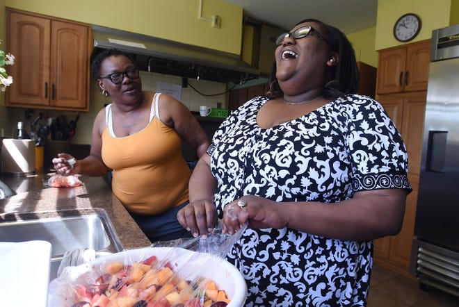Rene Walker, left, and Nikki Knight, right, residents at the Mercy Center for Women, prepare lunch on Friday. The center is preparing for the 11th annual Purse and Pearl Luncheon event on May 22, which benefits its Dress for Success program. [JACK HANRAHAN/ERIE TIMES-NEWS]