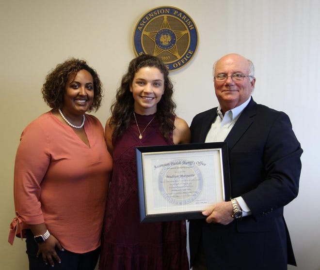 Madison Marquette (center) poses with Sheriff Jeff Wiley (right) and Allison Hudson (left) after receiving her scholarship from APSO.