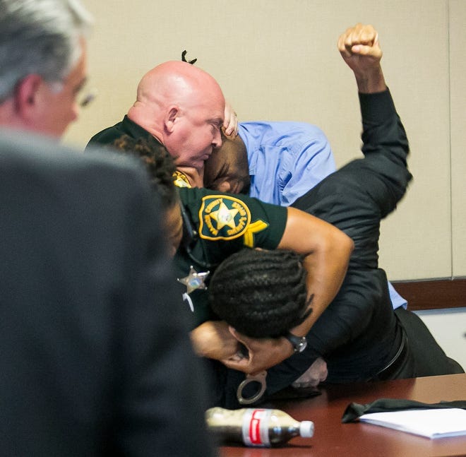 Bailiffs Tamra King puts defendant Travis Davis into a head lock as Bailiff Eugene Harper, top left, subdues Kelvon Grimmage after Davis punched his attorney Daniel Hernandez in Judge Steven Rogers' courtroom on May after the verdict was read in the murder trial of Courtney London. [Doug Engle/Staff photographer]