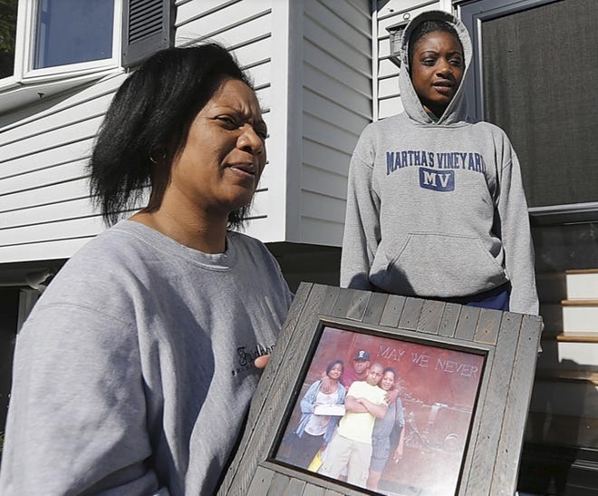 Solange Bell carries a family photo with her son David in the center. David Bell was one of four Stoughton teenagers killed in a car crash in East Bridgewater on Saturday. His sister, Sierra, stands behind the photo.

[Dave DeMelia / Brockton Enterprise]