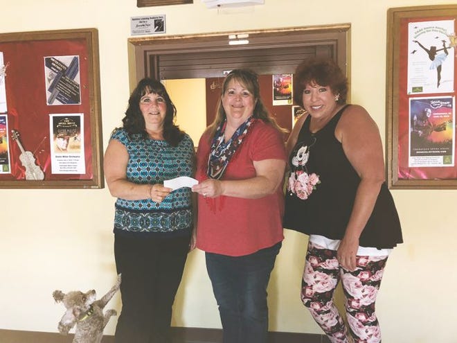 Julie Wilkinson, president of the Rivertown Follies, presents a check for $2000 to the Opera Houses' Kathy Hart and Rose Cesa. This's springs production of the "Totally Awesome 80s Show" benefited the historic facility.