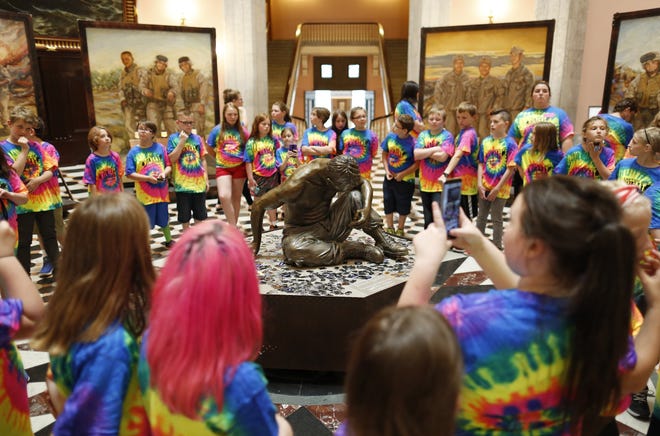 Fourth-grade students from Stanton Elementary in Hammondsville, Jefferson County, stop to see the bronze statue titled "Silent Battle" made by Ohio artist Anita Miller as part of the Eyes of Freedom exhibit at the Statehouse. The exhibit honors the Lima Company Marines and runs through Sunday. [Adam Cairns / Dispatch]