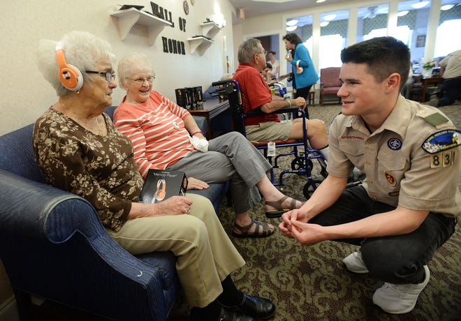 Millie Sullivan, left, reacts to music being played on a Memory Player while Lois Bauder and Andrew Vollmer, 17, watch. The Findlay Township Boy Scout Troop recently donated the devices to residents of Northview Estates nursing home in Ellwood City.

[Sally Maxson/ECL staff]