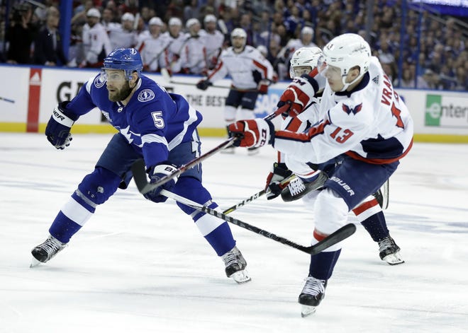 Washington Capitals left wing Jakub Vrana (13) takes a shot past Tampa Bay Lightning defenseman Dan Girardi (5) Wednesday during the first period of Game 7 of the NHL Eastern Conference finals in Tampa. [THE ASSOCIATED PRESS / CHRIS O'MEARA]