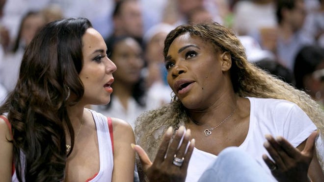 Tennis player Serena Williams, right, talks with Adrienne Bosh, wife of Miami Heat center Chris Bosh, during a playoff game against the Indiana Pacers at American Airlines Arena in Miami in 2014. She just sold a vacant lot for $6 million that she owned in Bears Club in Palm Beach Gardens, according to a deed recorded by the Palm Beach County Clerk’s office. (Allen Eyestone / The Palm Beach Post)