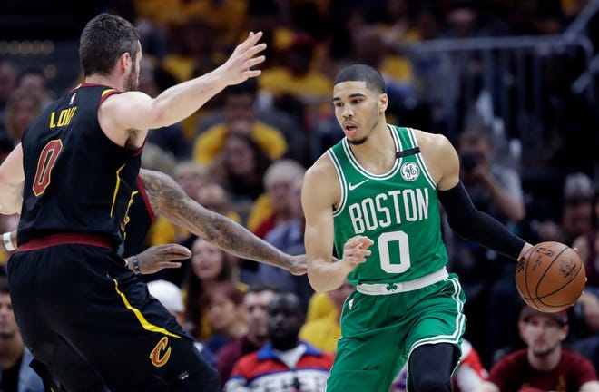 Boston's Jayson Tatum, right, looks to drive against Cleveland's Kevin Love Monday night in Cleveland.