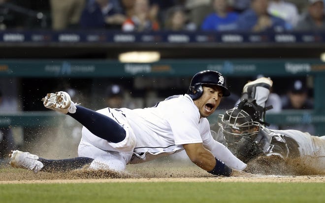 Detroit Tigers' Leonys Martin, left, slides safely into home plate as Chicago White Sox catcher Omar Narvaez reaches for the tag in the eighth inning of a baseball game in Detroit, Friday, May 25, 2018. (AP Photo/Paul Sancya)