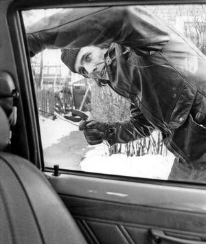 In a photo from May 1982, reformed car thief Rufus "Tinker" Whittier shows how it's done. Using a coat hanger and a screwdriver, he unlocks a car and is inside within 20 seconds. After checking the car out, he disconnects the "theft-proof" alarm system and ignition-kill switch under the car, which took 15 seconds. One factor that has put a sizable dent in auto-theft rates in recent years: vehicle security systems have grown far more sophisicated. [[The Providence Journal, file / Andrew Dickerman]