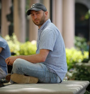 In this May 9, 2018 photo, Iraq War veteran Kristofer Goldsmith poses for a photo at a campus park after his last final exam of the semester at Columbia University in New York. Military veterans with less-than-honorable discharges from the military say they often can’t get jobs, and they hope a recent warning to employers by the state of Connecticut will change that. Goldsmith says that for veterans with bad paper, their service record looks more like a criminal record to potential employers. (AP Photo/Bebeto Matthews)