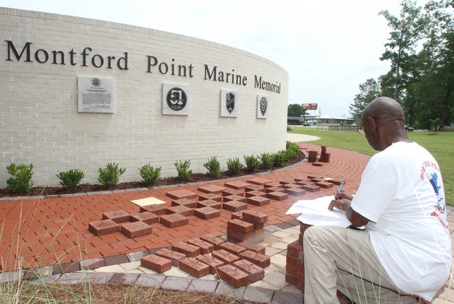 Houston T. Shinal, Montford Point Marine Association national momument director, organizes engraved donor bricks at the group's memorial site on May 22, in Jacksonville. [Mike McHugh / The Daily News]