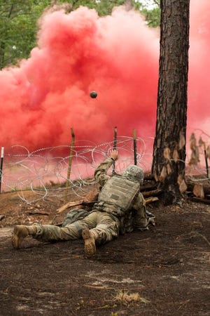 A Soldier throws a ball of tape into concertina wire to detect traps during an Expert Field Medical Badge test, May 17, at the Medical Simulation Training Center. The Expert Field Medical Badge tests include a written exam, land navigation skills and simulated combat challenges. For more photos, visit www.paraglideonline.net.