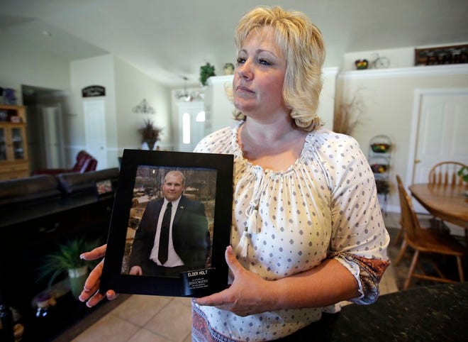 FILE - In this July 13, 2016 file photo, Laurie Holt holds a photograph of her son Josh Holt at her home, in Riverton, Utah. Josh Holt has been released from a jail in Venezuela after spending nearly two years behind bars on weapons charges. Utah Sen. Orrin Hatch said on Twitter Saturday, May 26, 2018, that Joshua Holt had been released. President Donald Trump tweeted that it was “good news,” adding that Holt “should be landing in D.C. this evening and be in the White House, with his family, at about 7:00 P.M.” (AP Photo/Rick Bowmer, File)