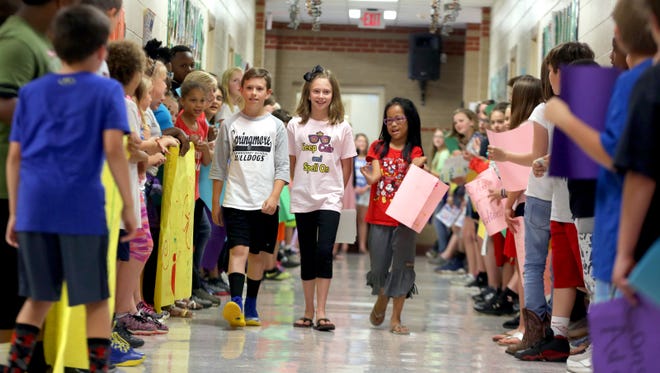Addison Champion parades through the hallways of Springmore Elementary School with friend Parker Ledbetter, left, and Madelyn Kratzer on Friday. Champion will compete in the Scripps National Spelling Bee next week. [Brittany Randolph/The Star]