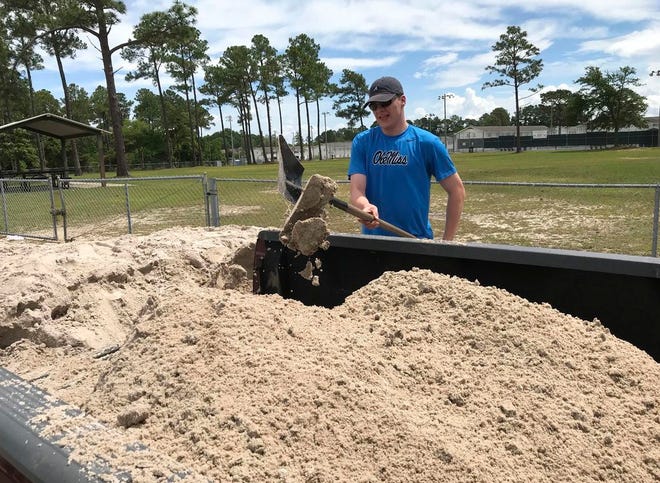 Nicholas Filipich of Biloxi, Miss., shovels sand for sand bags into his grandfather's truck on Friday. Filipich was helping his grandfather prepare for expected heavy rains over the weekend.