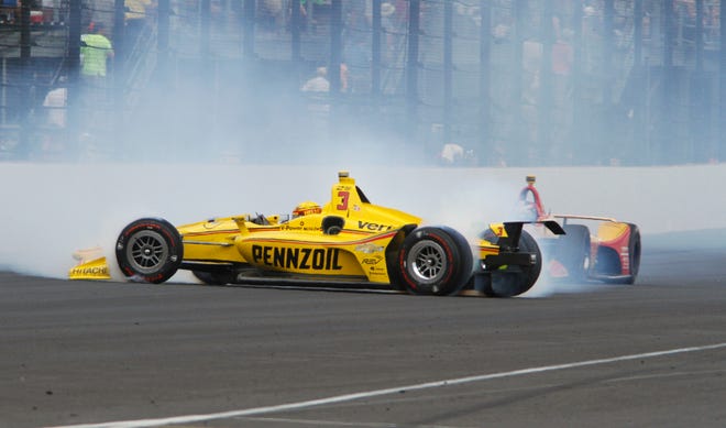 Helio Castroneves slides into the pit area after hitting the wall in the fourth turn during Sunday's Indianapolis 500. [Mike McKown/The Associated Press]