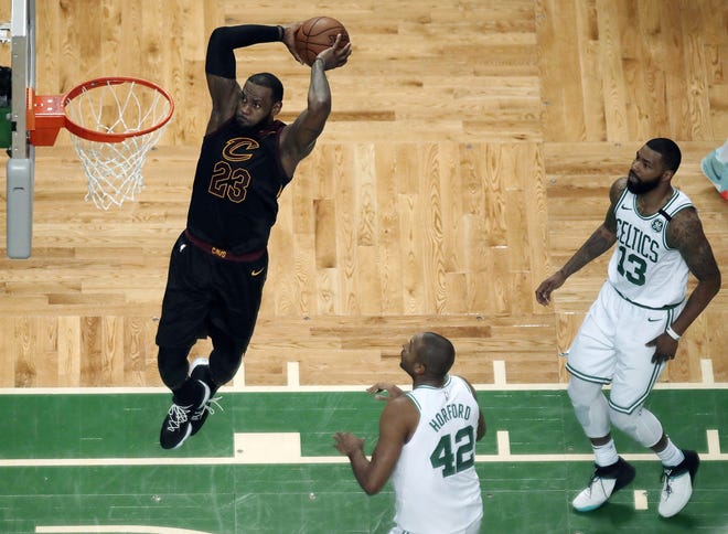 Cleveland Cavaliers forward LeBron James soars to dunk in front of Boston Celtics forward Al Horford (42) and forward Marcus Morris (13) during the first half in Game 7 of the NBA basketball Eastern Conference finals Sunday, May 27, 2018, in Boston. [AP Photo/Charles Krupa]