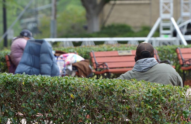 Homeless people sit on the benches in Towne Square in downtown Leesburg. The Leesburg City Commission, at the urging of area merchants, on Tuesday approved an ordinance banning what they call "aggressive panhandling." [Whitney Lehnecker/Daily Commercial]