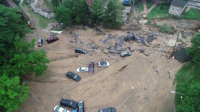 This image made from video provided by DroneBase shows vehicles swept by floodwater near the intersection of Ellicott Mills Drive and Main Street in Ellicott City, Md., Monday, May 28, 2018. Howard County Executive Allan Kittleman said Monday morning that his priorities are finding a missing man and assessing the condition of buildings that house shops, restaurants and families. (DroneBase via AP)