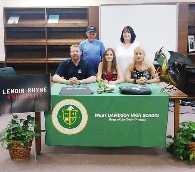 Hayden and Melissa Martin (standing from left), Coach Kevin Troy (sitting, from left), Angel Martin and cross-country Coach Lynn Ludwig look on as Angel Martin signs with Lenoir-Rhyne University. [Contributed photo]