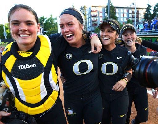 Oregon catcher Gwen Svelos, pitcher Miranda Elish, Lauren Lindvall and Jenna Lilley, from left, celebrate the team's win over Kentucky in an NCAA softball tournament super regional, Saturday, May 26, 2018, in Eugene, Ore. (Chris Pietsch/The Register-Guard via AP)
