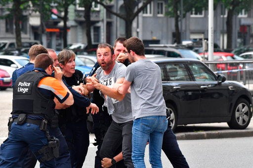 Police try to calm a man at the scene of a shooting in Liege, Belgium, Tuesday, May 29, 2018. A gunman killed three people, including two police officers, in the Belgian city of Liege on Tuesday, a city official said. Police later killed the attacker, and other officers were wounded in the shooting.(AP Photo/Geert Vanden Wijngaert)