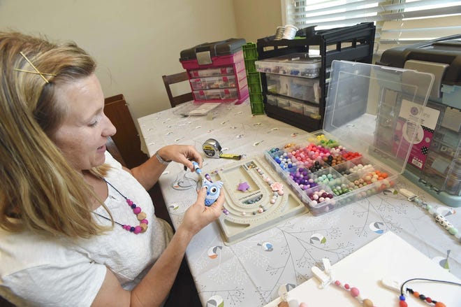 Kelly Julian makes a pacifier clip at her home in Fort Walton Beach. Julian started out making personalized pacifiers and teething rings for fellow military families with new babies. She now makes and sells the items at local retailers, craft fairs and online. [PHOTOS BY DEVON RAVINE/DAILY NEWS]