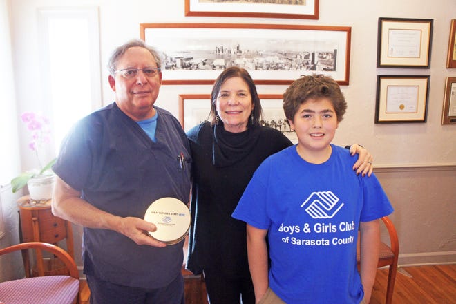 Dentist Steven Feldman and his wife, Karen, pose with Boys & Girls Club member Trae Spencer. The Boys & Girls Clubs are one of several area nonprofits that have benefited from the Feldmans’ charitable giving campaign. [COURTESY PHOTO]