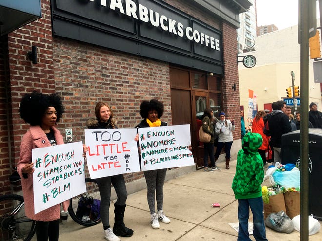 FILE – In this April 15, 2018, file photo, demonstrators protest outside the Starbucks cafe in Philadelphia where two black men were arrested three days earlier for waiting inside without ordering anything. On Tuesday, May 29, 2018, the company plans to close more than 8,000 stores nationwide to conduct anti-bias training, a move intended to show how serious the company is about living up to its now tarnished image as a neighborhood hangout where all are welcome. (AP Photo/Ron Todt, File)