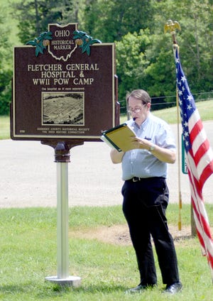 Rick Booth reads the text on the opposite side of the marker Monday afternoon at the Dedication and Unveiling of the Fletcher General Hospital & WWII POW Camp Historical marker. The marker is located at 66715 Old Twenty-One road in Cambridge near the original entrance of the hospital grounds. Congressman Bill Johnson among others attended the dedication ceremony.