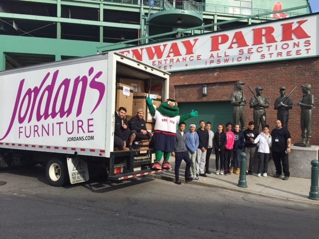 Jordan’s Furniture delivered a truck full of baseball and softball equipment to Fenway Park for the Red Sox Foundation’s inner city youth baseball and softball program. Over 32 boxes (the size of living room recliners) were filled with donated equipment. [Submitted photo]
