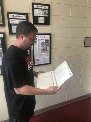 Landrum basketball coach Lyn Smith recently discovered the scorebook from the Cardinals' 1975 state baseball title season. It was the first championship in school history. The book is now displayed in the school's athletic trophy case. [JED BLACKWELL/Spartanburg Herald-Journal]